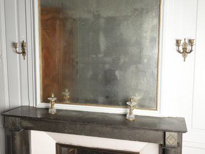 a fireplace with a mirror on top of it in a room