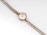 a close up of a wrist watch with a chain around it