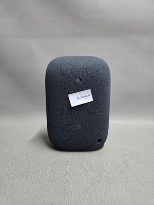 un gros plan d'une enceinte connectée posée sur une surface blanche