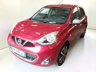 La voiture rouge est garée sur le sol blanc de la pièce.