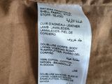 the label on the back of a brown jacket shows the price of the item