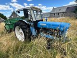 un tracteur qui est à l'arrêt dans l'herbe, dans le champ