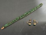 ensemble composé d'un bracelet et de boucles d'oreilles ornés de pierres vertes sur un fond noir