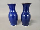 pair of blue vases sitting on top of a white table
