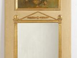 a mirror on the wall with a vase of flowers on it