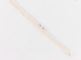 gros plan d'un collier de perles blanches sur une surface blanche