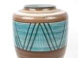 a blue and brown vase sitting on a white surface