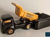 a black toy truck with a yellow dump truck in the back