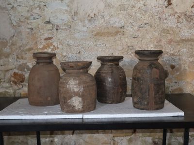 quatre vases posés sur une table devant un mur de briques