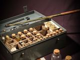 a metal box filled with glass bottles and a wooden stick
