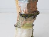 a close up of a vase made of paper and wood