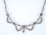 un collier en argent orné d'un bouquet de perles de cristal sur fond blanc