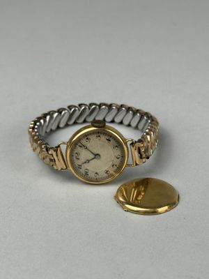 an image of a gold and silver wrist watch and a gold button