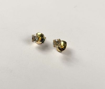 a pair of gold and diamond stud earrings on a white surface