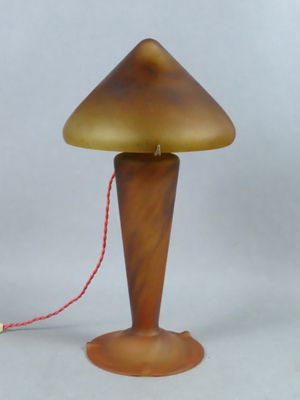 une image représentant une lampe posée sur une table, avec un cordon rouge