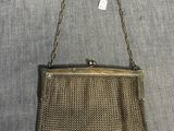 un vieux sac à main en maille dorée, muni d'une chaîne