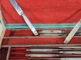 six knives in a case with a red cloth