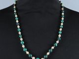un collier de perles vertes et blanches sur un mannequin, un mannequin, un mannequin, un mannequin, un mannequin, un mannequin, un mannequin, un mannequin, un mannequin, un mannequin