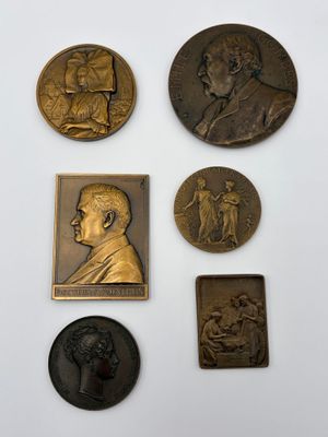 a group of five bronze plaques of a man and a woman