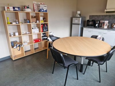 une table et des chaises dans une pièce où se trouve une bibliothèque