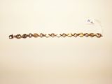 a close up of a gold bracelet with a chain attached to it