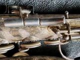 a close up of a silver saxophone with a black background