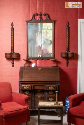 deux fauteuils rouges dans un salon où un miroir est accroché au mur