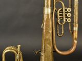 an old brass trumpet and a small brass instrument