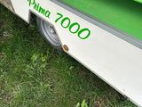 a small green and white food cart on the grass