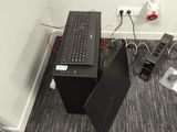 a black computer sitting on top of a desk next to a computer monitor