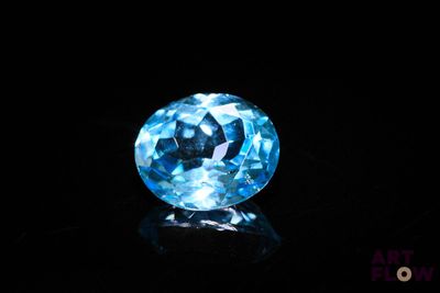 a close up of a blue diamond on a black surface