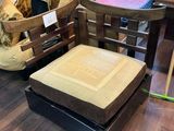 un fauteuil et un pouf dans une pièce où se trouvent une table et des chaises