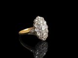 une vieille bague à diamants taillés disposés en grappe, posée sur une surface noire