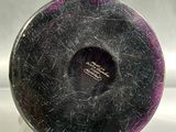 a black and purple vase sitting on top of a white counter