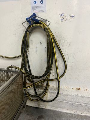 un gros tuyau fixé au mur, à côté d'un panier en métal