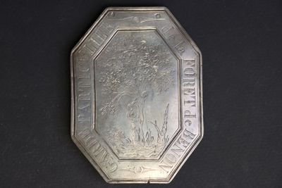 an antique silver plate with a picture of a man on a horse