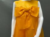 an image of a mannequin wearing a yellow dress with a large bow