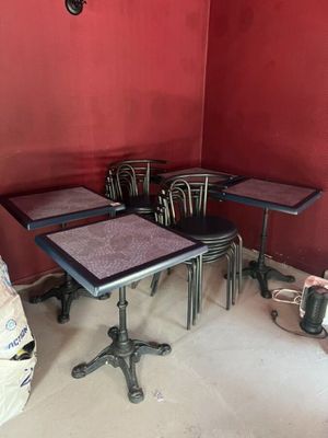 plusieurs tables et chaises dans une pièce dont l'un des murs est rouge