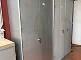 several metal lockers in a room with a red wall