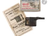 un vieux pistolet est posé à côté d'un paquet de cigarettes