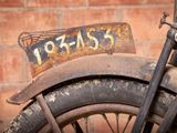 an old motorcycle with a rusted license plate on it