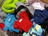 une valise pleine de vêtements posée par terre