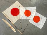 deux drapeaux japonais et une paire de baguettes posés par terre