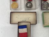 three medals and a medal in a display case on a table