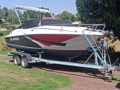a boat on a trailer parked on the side of the road