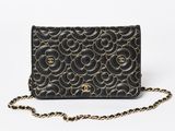 a black and gold purse with a chain around it