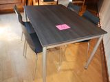 a wooden table with four chairs and a pink sticker on it