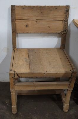 une chaise en bois posée dans un coin d'une pièce