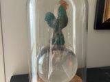 une cloche en verre contenant un cactus, posée sur une table