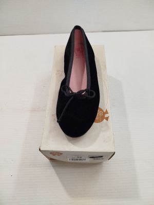 quelqu'un porte une paire de chaussures noires sur une surface blanche